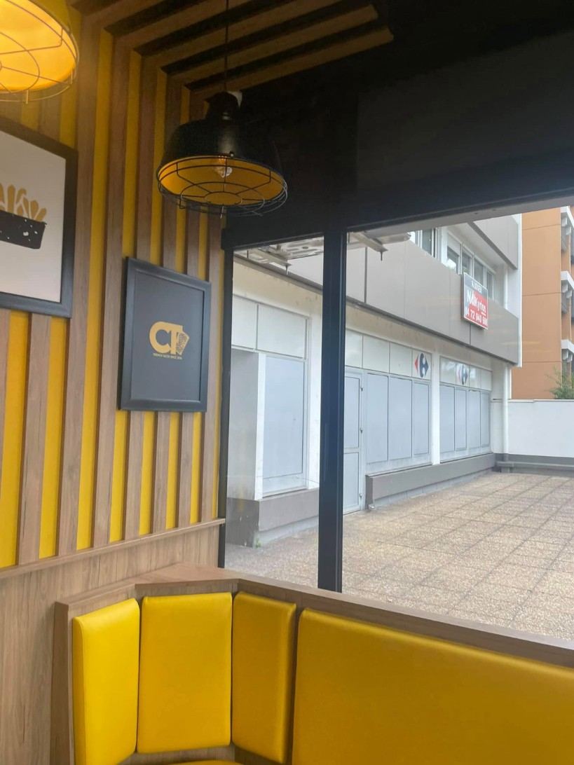 Snack avec bardage bois et jaune, banquettes jaunes
