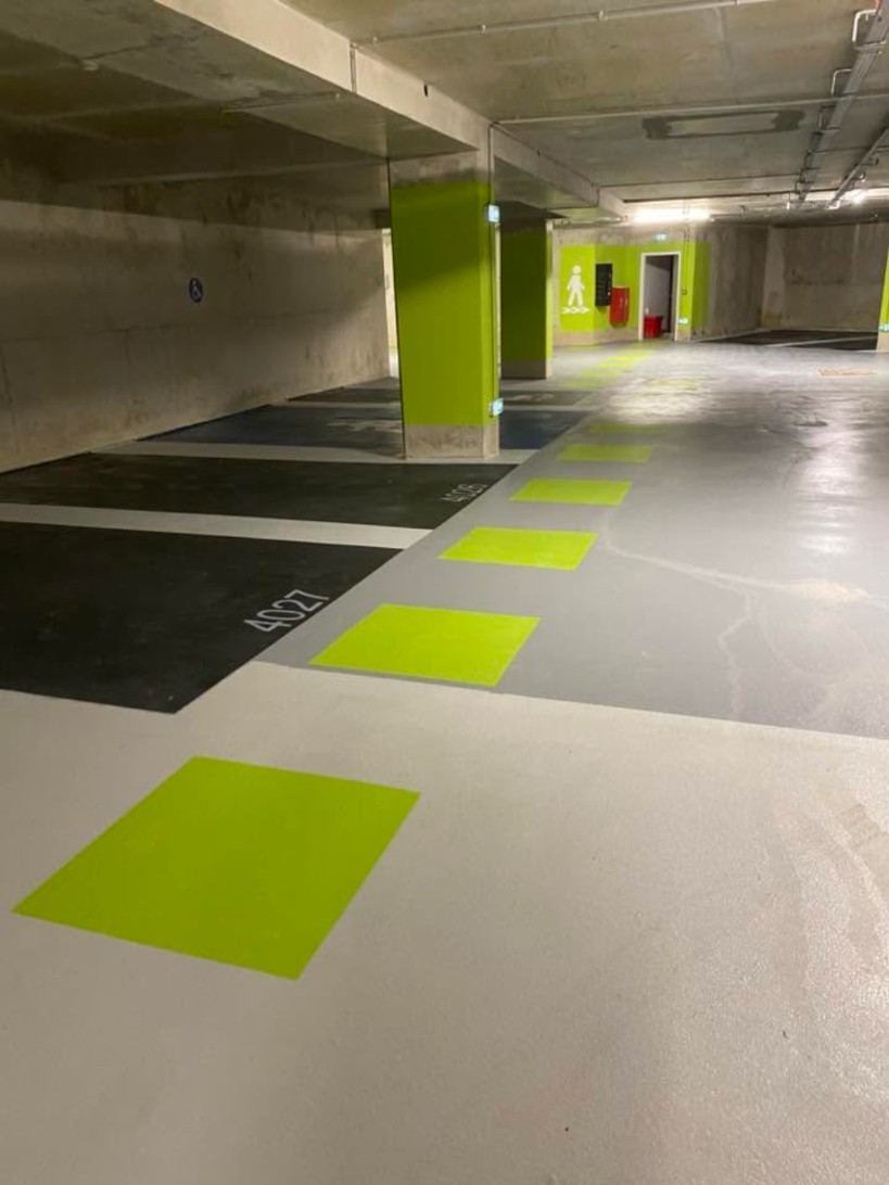 Parking souterrain en résine grise avec carrés vert anis