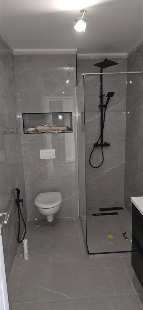 Salle de bains en grès gris, douche à l'italienne et paroi vitrée